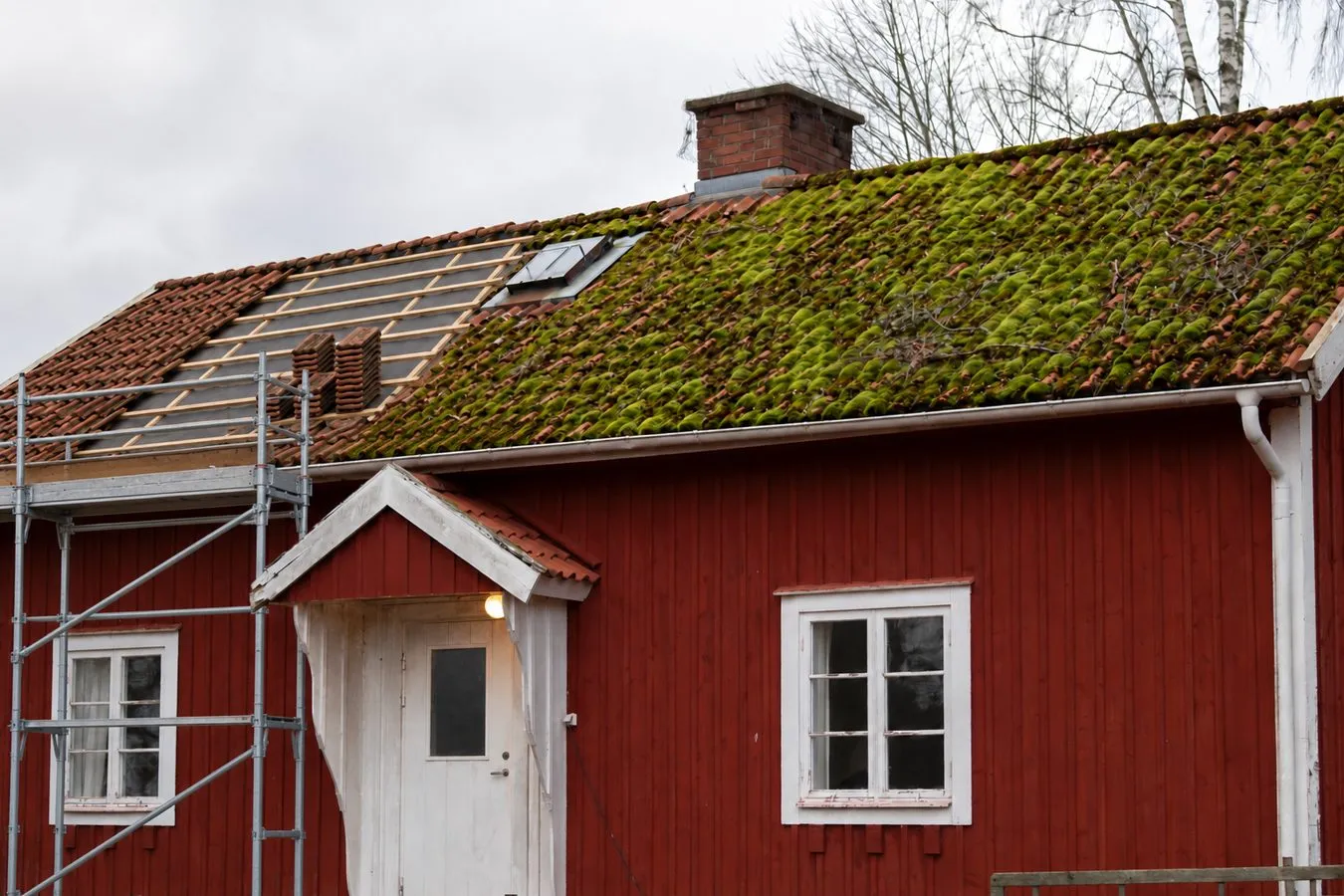 Takomläggning av tegeltak: de gamla tegelpannorna har lyfts av och rengjorts, ny underlagsduk och läkt är på plats och pannorna ligger staplade för att läggas tillbaka